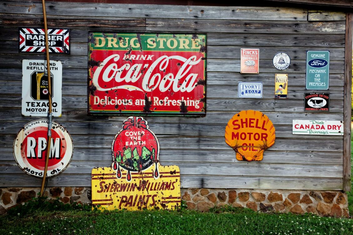 Vintage signage including Drug Store Drink Coca Cola Signage on Gray Wooden Wall
